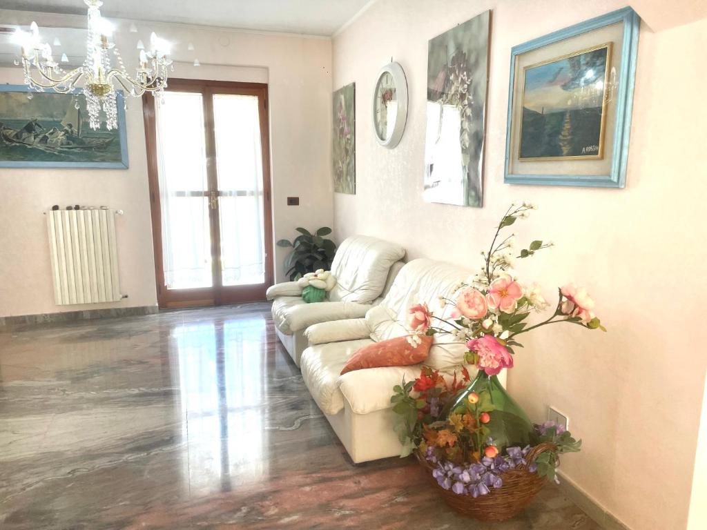 马蒂纳塔La Vie en Rose Mattinata的客厅配有沙发,地板上鲜花