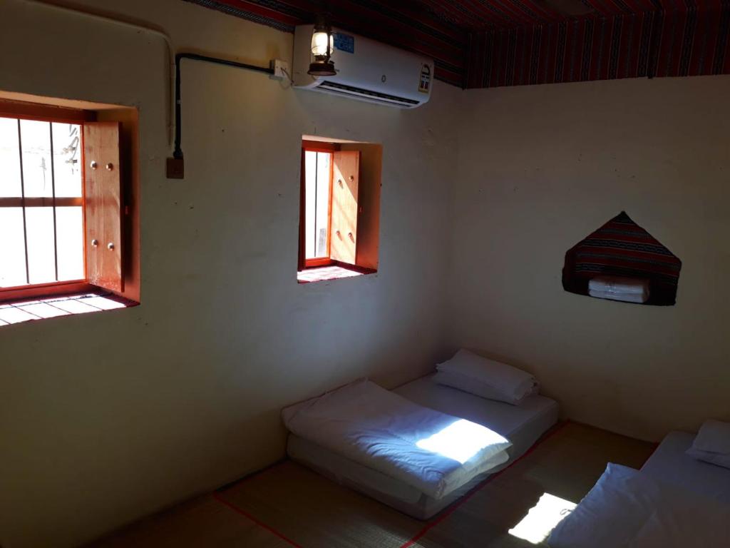 Bilād SaytBalad Sayt Heritage Inn的带两张床和两个窗户的房间