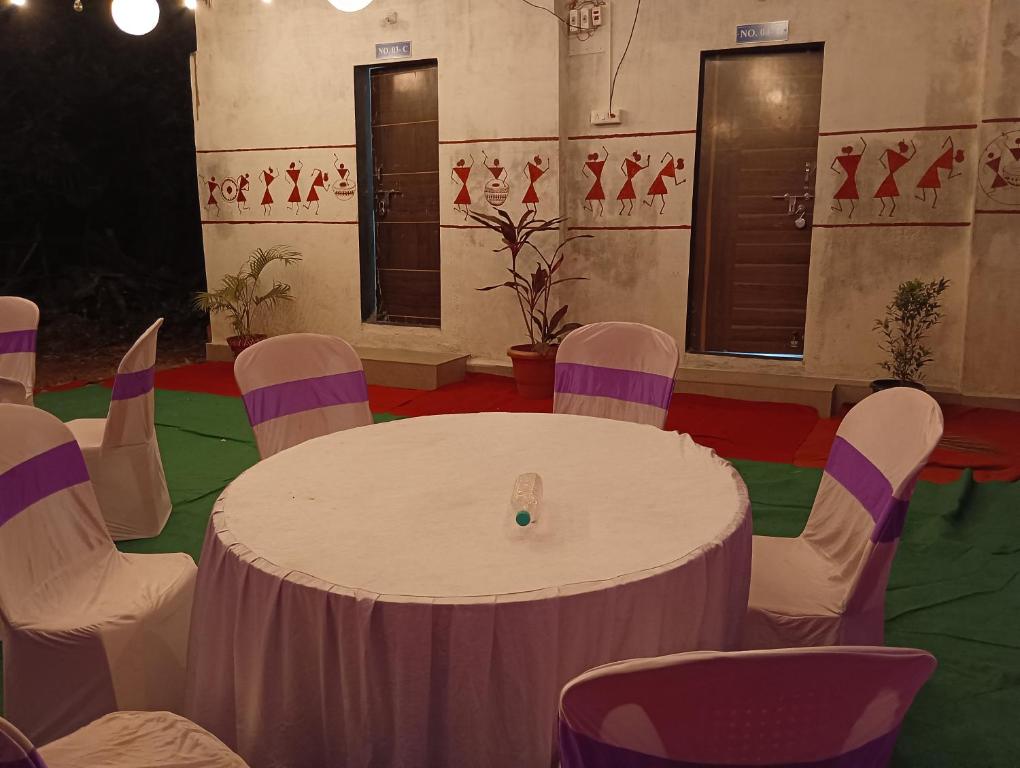 阿利鲍格Mhatre Cottage Alibag Mani的配有白色桌子和椅子的房间