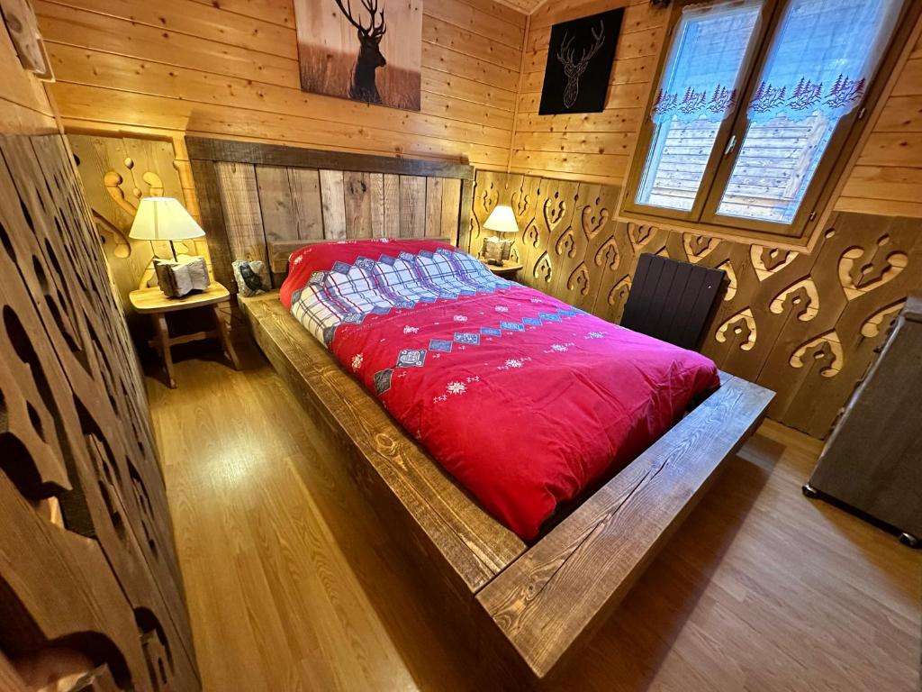 Saint-Laurent-en-GrandvauxRefuge des Cimes的木制客房内的一张红色床