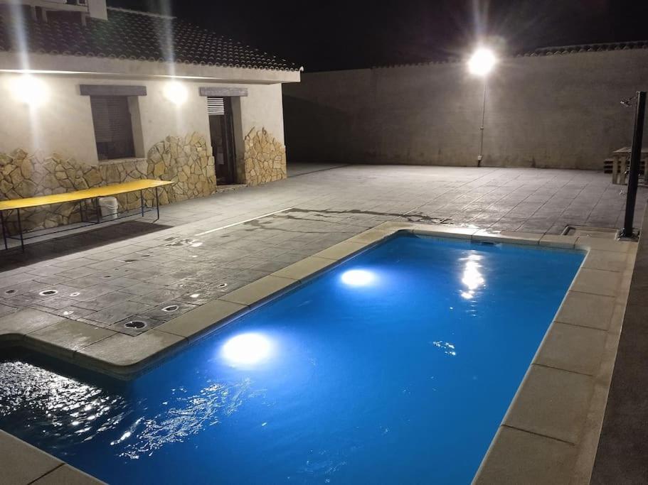 La Puebla de MontalbánEl capricho de Diego的一座大型蓝色游泳池,晚上在大楼里