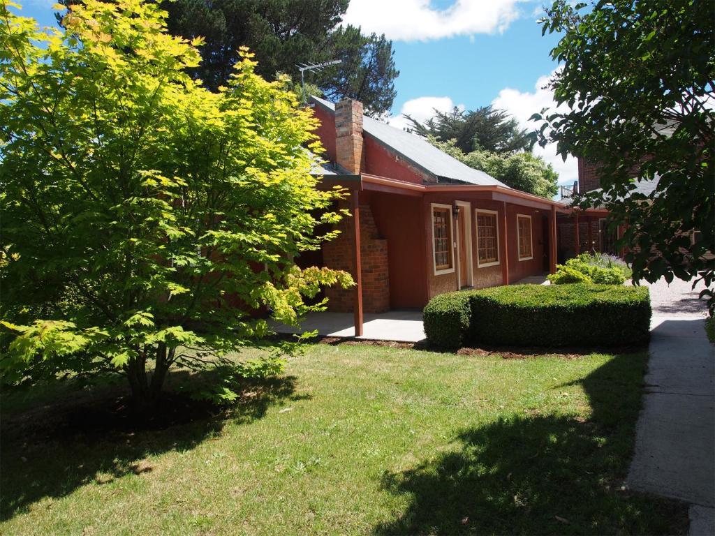 德洛兰塔哈拉度假屋的一座带草地庭院的红色小房子