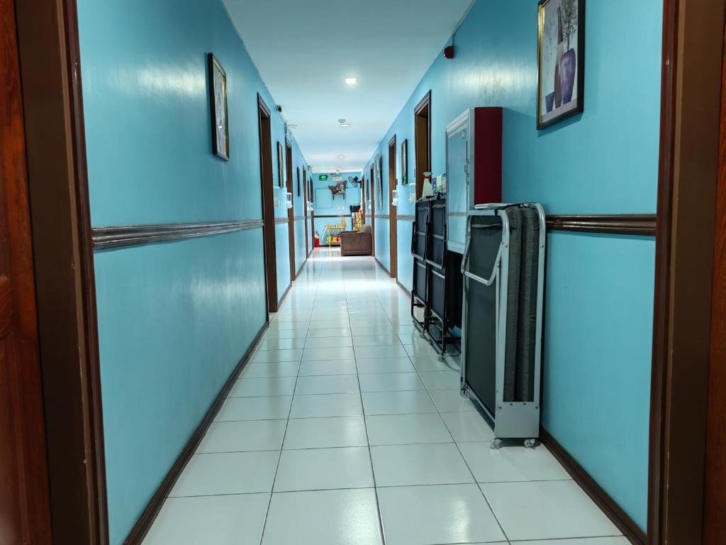 达沃市YellowPad Hotel (SM-Eco)的医院的走廊,有蓝色的墙壁和白色的瓷砖地板