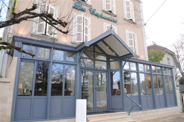 阿瓦隆Logis Hôtel Restaurant Les Capucins的一座带蓝色门的建筑和一座建筑
