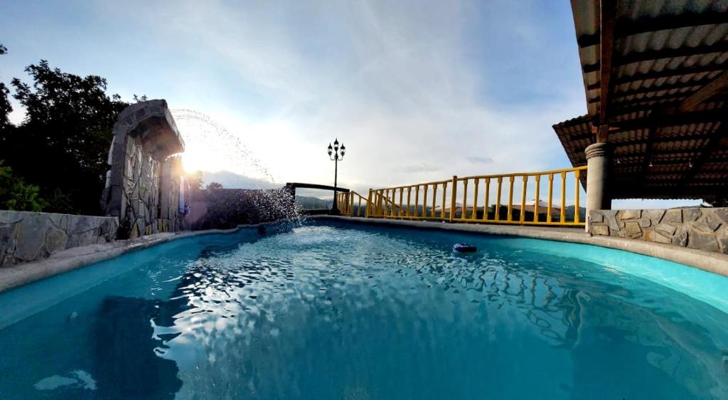 希利特拉Hotel Posada San Agustin的一座大型蓝色游泳池,位于大楼旁边