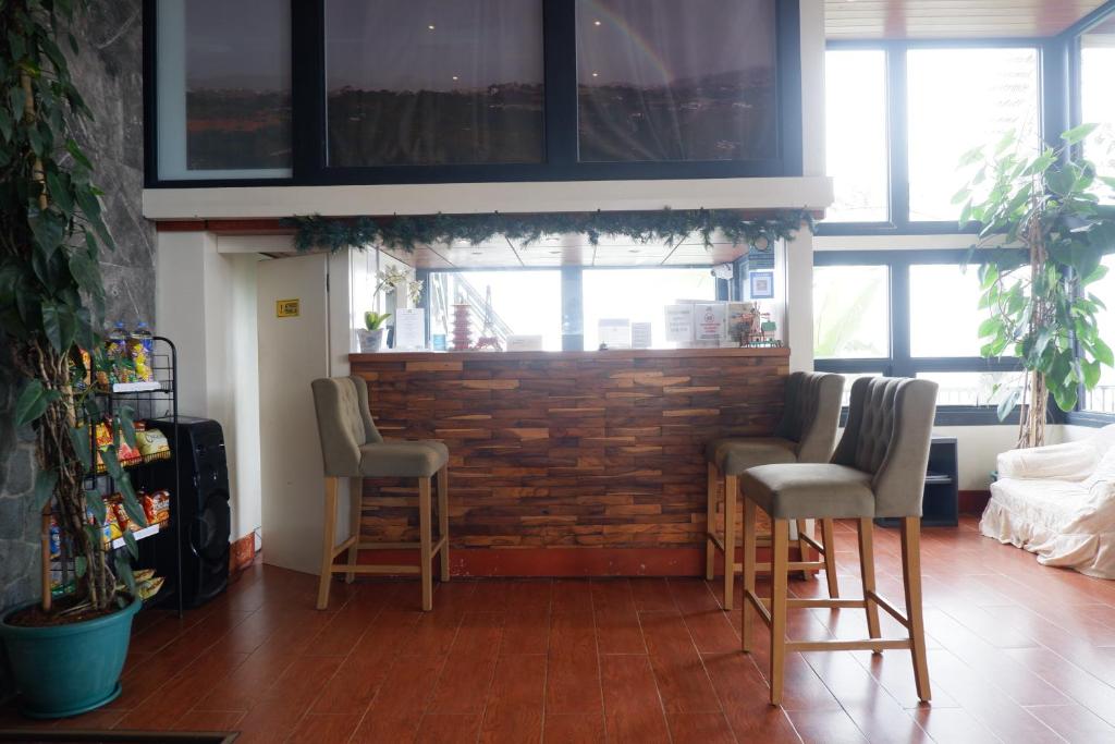 碧瑶Sunset View Ridge Residences的一间酒吧,配有四把椅子和砖墙