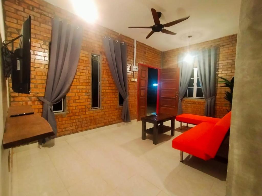 珍南海滩The RedBrick's Homestay Langkawi的客厅设有红色沙发和砖墙