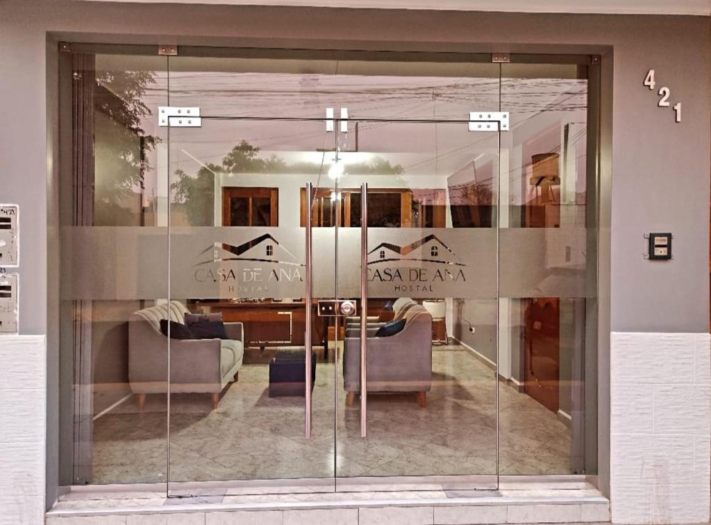 纳斯卡Hostal Casa de Ana的客厅的玻璃墙,配有两张沙发