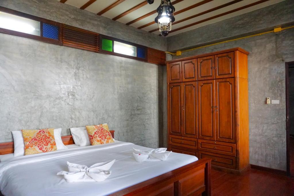 清迈Tamnak Lanta @Chiang Mai的卧室配有白色大床和木制橱柜