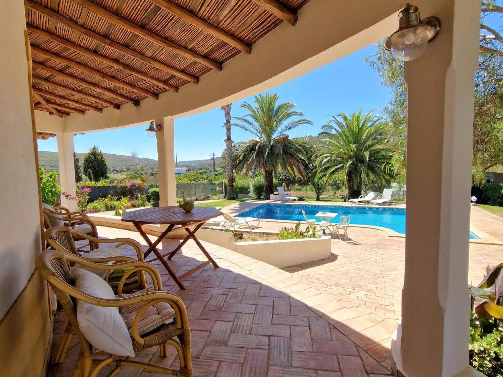 本萨夫林Casa da Aldeia的一个带桌椅的庭院和一个游泳池