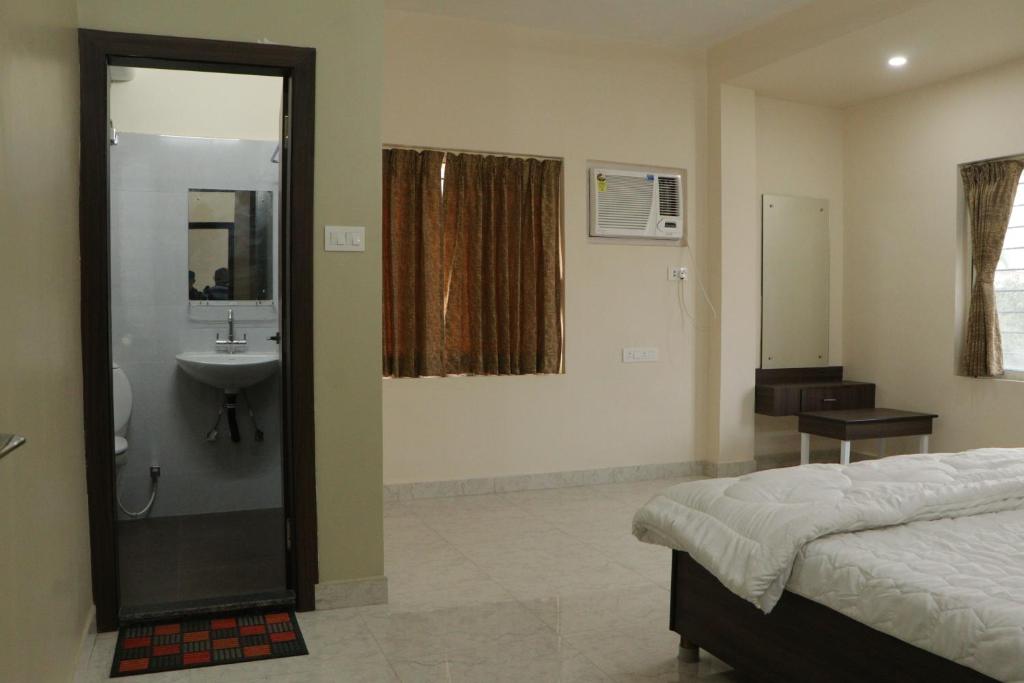 加尔各答Radharani Apartment的一间卧室设有淋浴、水槽和一张床
