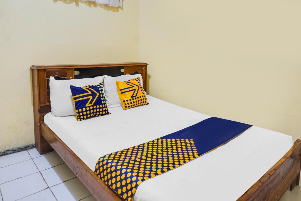 岩望OYO Life 92087 Griya Nurainy的一张黄色和蓝色枕头的床