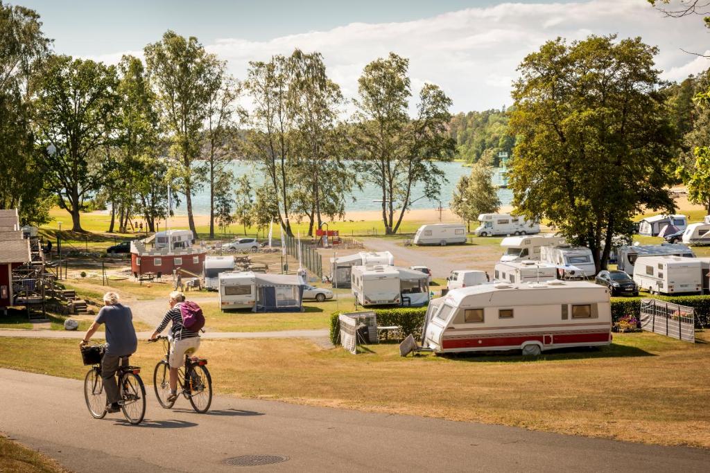 尼奈斯港First Camp Nickstabadet-Nynäshamn的两个人骑着自行车沿着营地附近的一条公路行驶