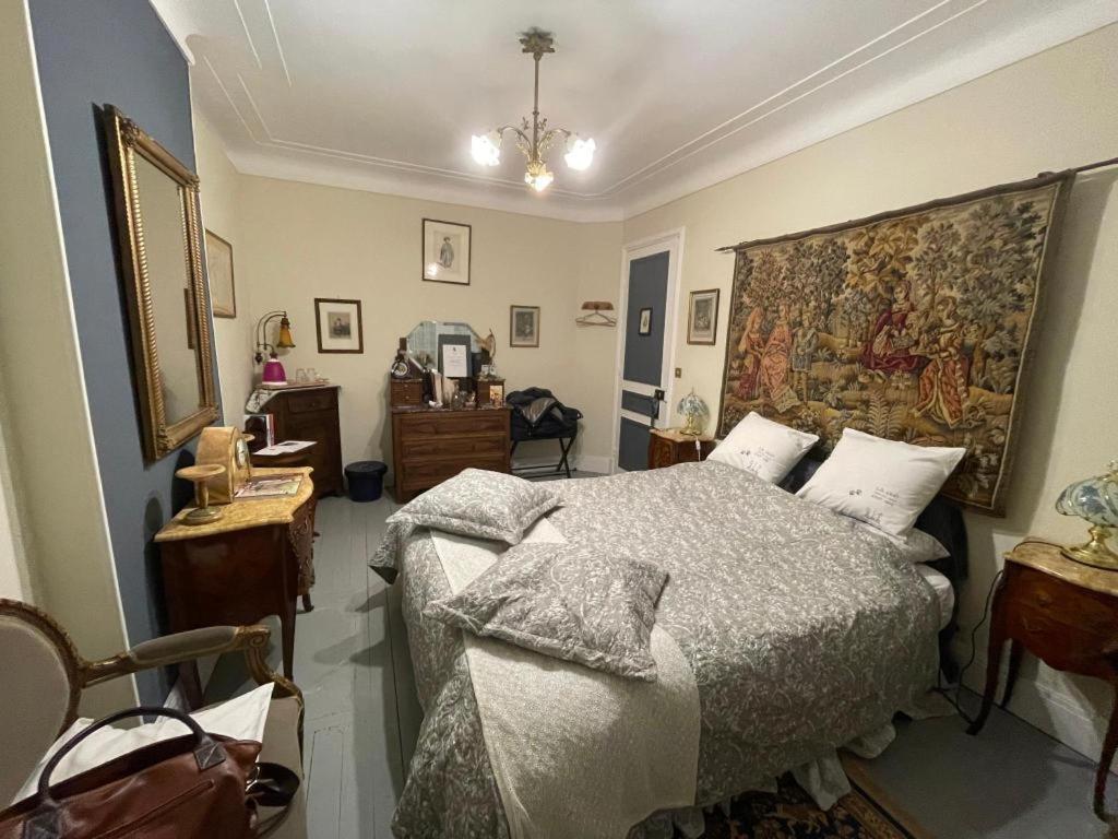 加来Villa des Chats的卧室配有一张床,墙上挂着挂毯