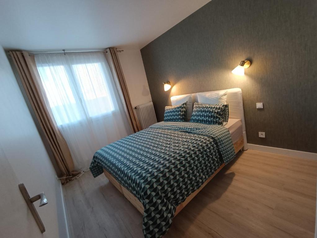 谢勒Chelles centre ville 2 chambres près des bords de Marne 10 minutes à pieds de la Gare de Chelles-Gournay 5 minutes de la gare de Vaires-sur-Marne 20 minutes de Disneyland jusqu'à 5 couchages possibles的一间卧室配有一张带蓝色毯子的床和窗户。