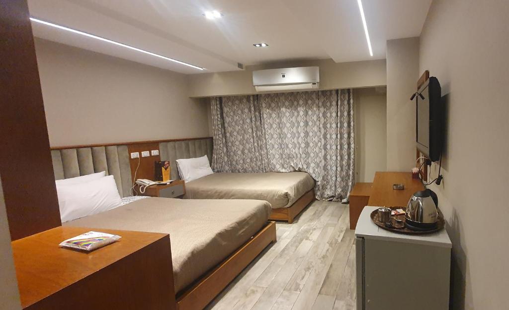 开罗Garden City Plaza Hotel的酒店客房设有两张床和电视。