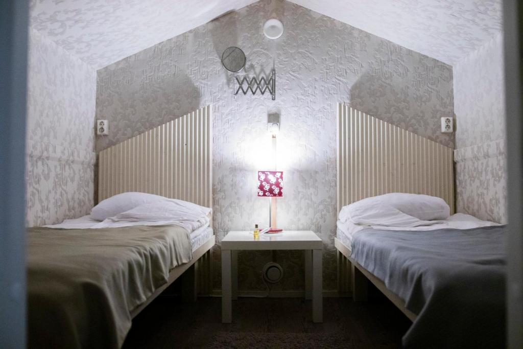 Orimattila泰尔塔酒店的客房设有两张床和一张带台灯的桌子。