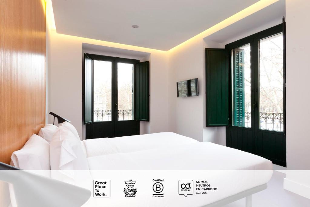 马德里SLEEP'N Atocha - B Corp Certified的卧室配有白色的床和2扇窗户。