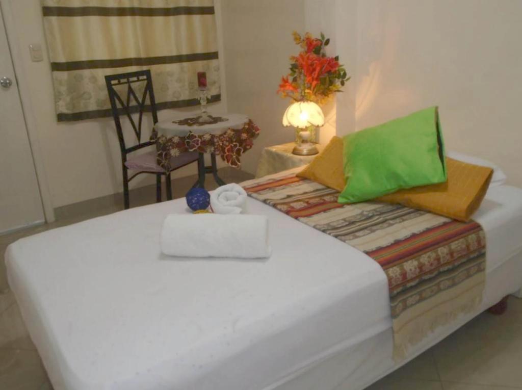 瓜亚基尔Hotel Jeshua Simmonds的一张位于带桌子和椅子的房间内的床铺