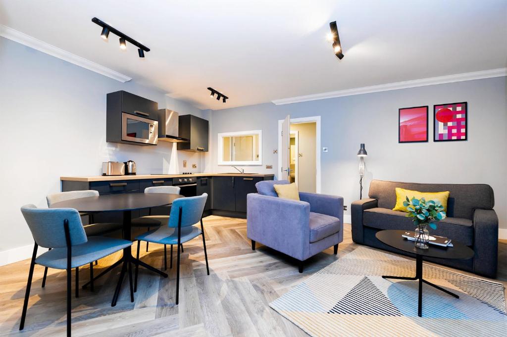 都柏林Staycity Aparthotels, Dublin, Christchurch的客厅以及带桌椅的厨房。