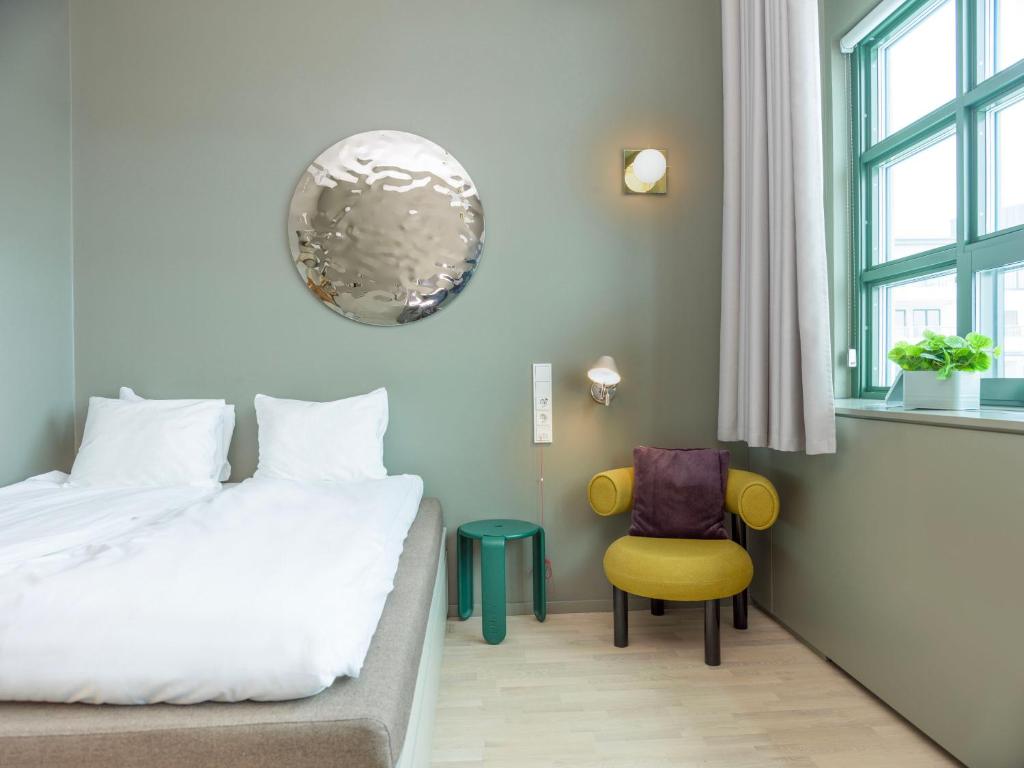 斯德哥尔摩UNITY Hammarby Sjöstad的配有一张床和一把椅子的酒店客房