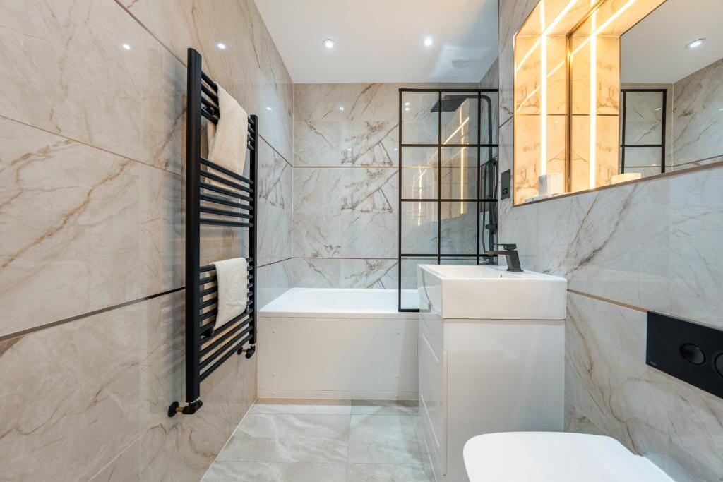 伦敦Brand New London Luxury House - Sleeps 8的带浴缸、卫生间和盥洗盆的浴室