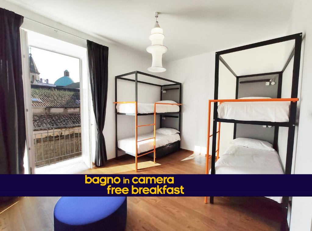 那不勒斯Tric Trac Hostel的一间卧室设有两张双层床和一扇窗户。