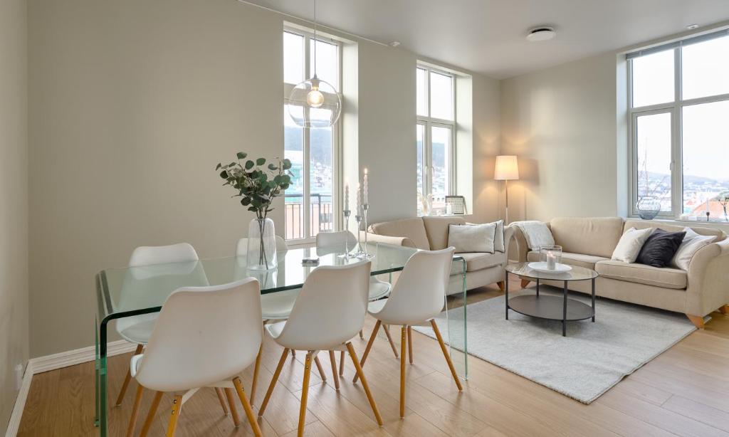卑尔根Elegant Bergen City Center Apartment - Ideal for business or leisure travelers的客厅配有玻璃桌和白色椅子
