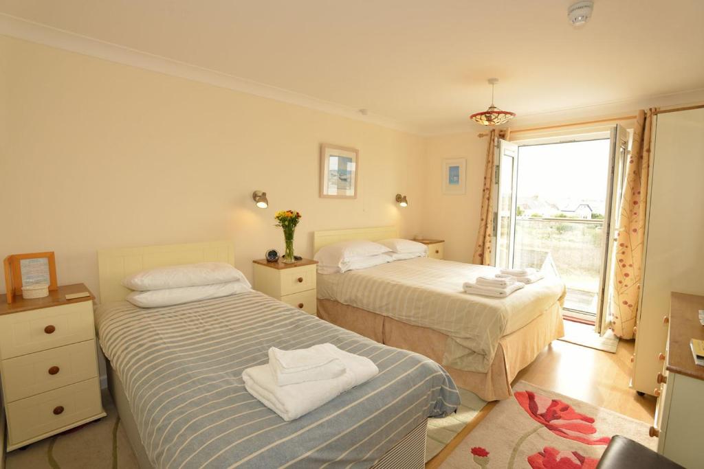 海尔Sandy Bay Apartment, St Ives Bay, Hayle的带窗户的客房内的两张床