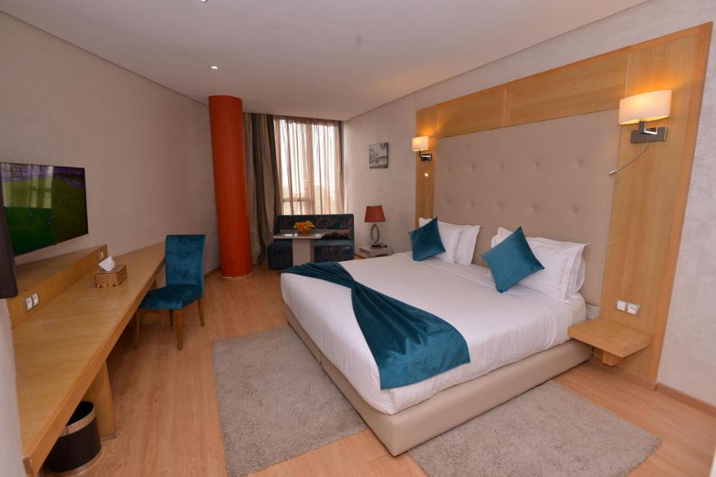 卡萨布兰卡Le 135 appart hotel的酒店客房设有一张大床和一张书桌。