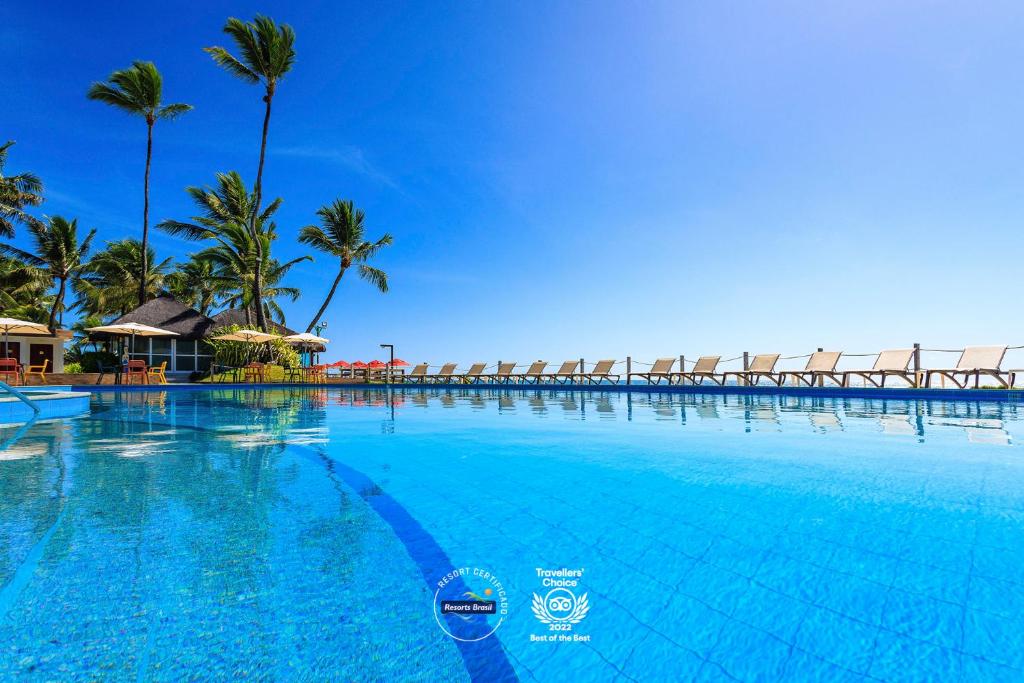 嘎林海斯港Armação Resort Porto de Galinhas的一座棕榈树环绕的大型游泳池