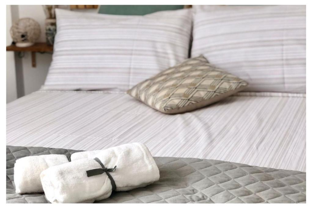 ColognaDèpendance immersa tra gli ulivi的白色的床、白色枕头和毛巾