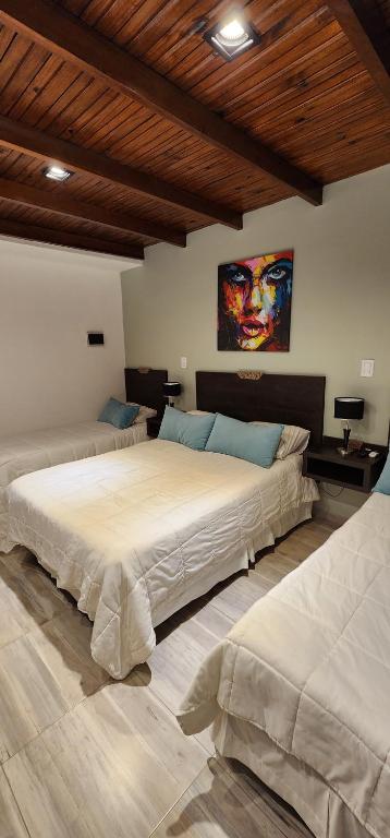 帕索德洛斯利布雷斯Nomades Apartamentos的一间卧室设有两张床,墙上挂着一幅画