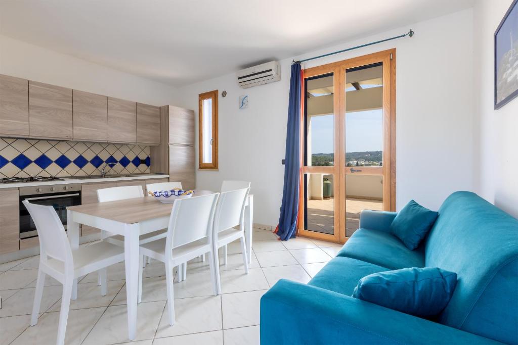 莱乌卡Appartamenti Marinelli - Santa Maria di Leuca的客厅配有桌子和蓝色沙发