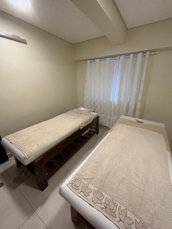 萨利诺波利斯SALINAS PARK RESORT的带窗户的客房内的两张床
