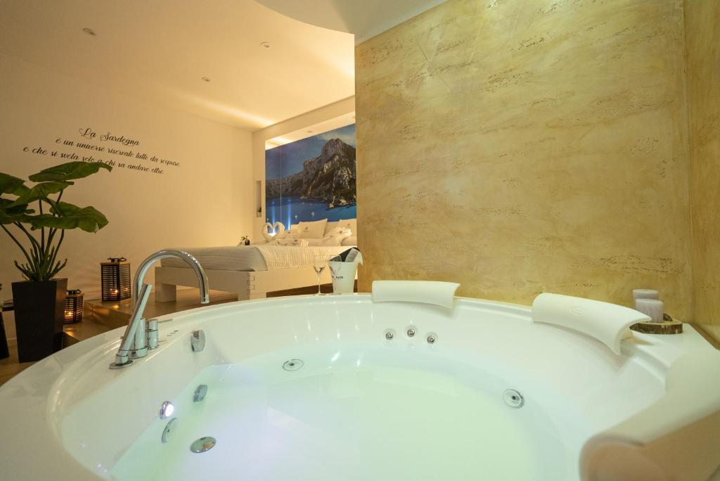 阿尔盖罗Sunshine Charming Houses的浴缸位于带墙壁的房间