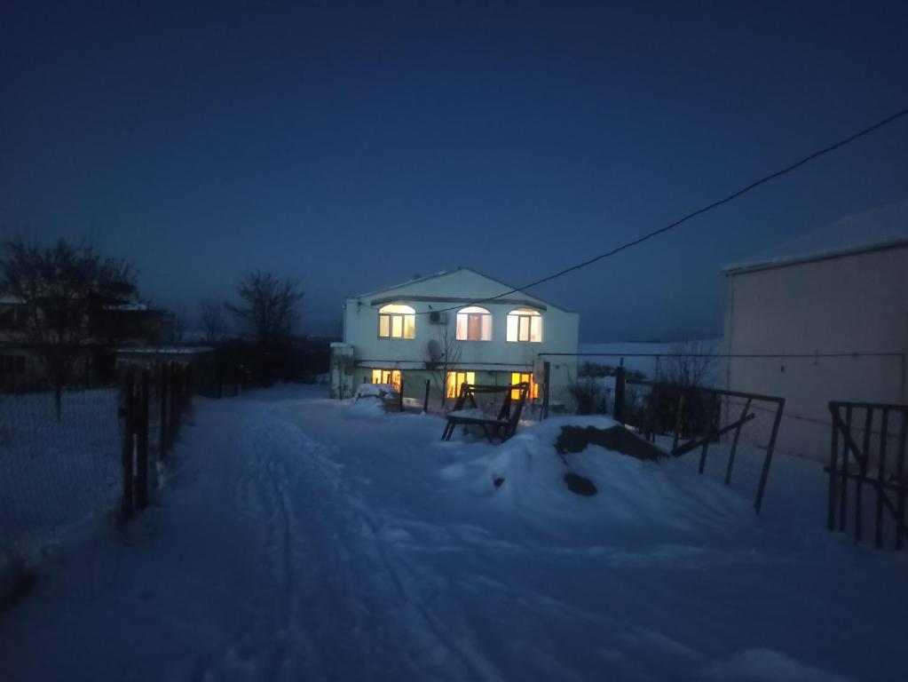 库巴Orchard的夜晚在雪中点亮的房子