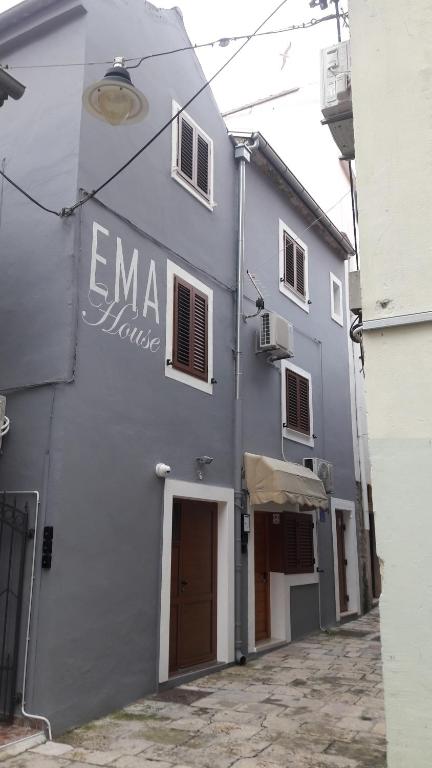 扎达尔EMA HOUSE的一座灰色的建筑,旁边有一个标志