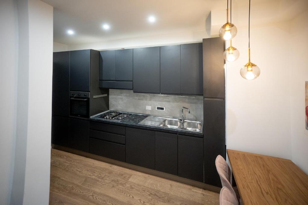 罗马Angelico Luxury House的厨房配有黑色橱柜和木桌
