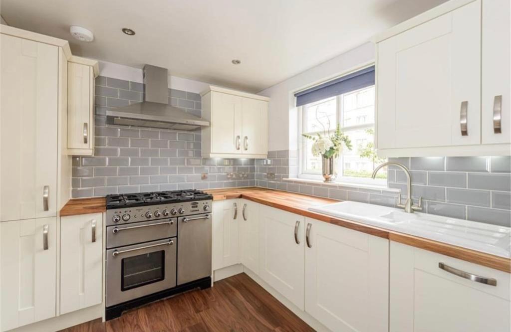 爱丁堡Modern Two Bedroom Apartment, Roseburn, Edinburgh - Free Parking的厨房配有白色橱柜和炉灶烤箱。