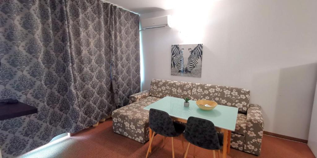 布尔加斯Seaview apartment - Clara Sarafovo - 100m to sea的客房设有桌子、沙发、桌子和椅子。