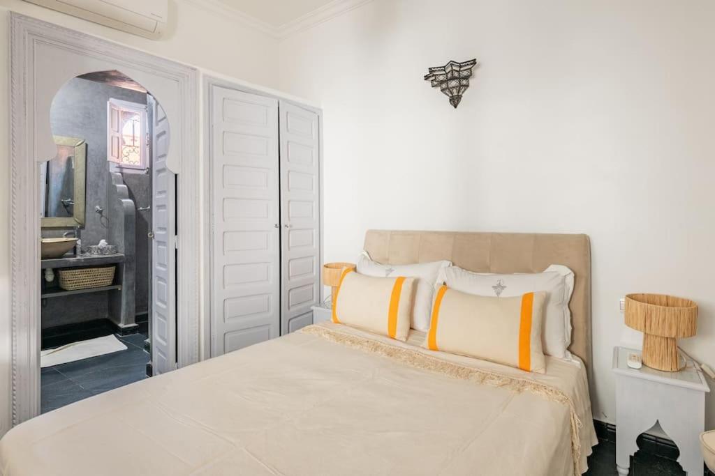 马拉喀什艾姆派尔摩洛哥传统庭院住宅的一间卧室配有黄色和白色枕头的床