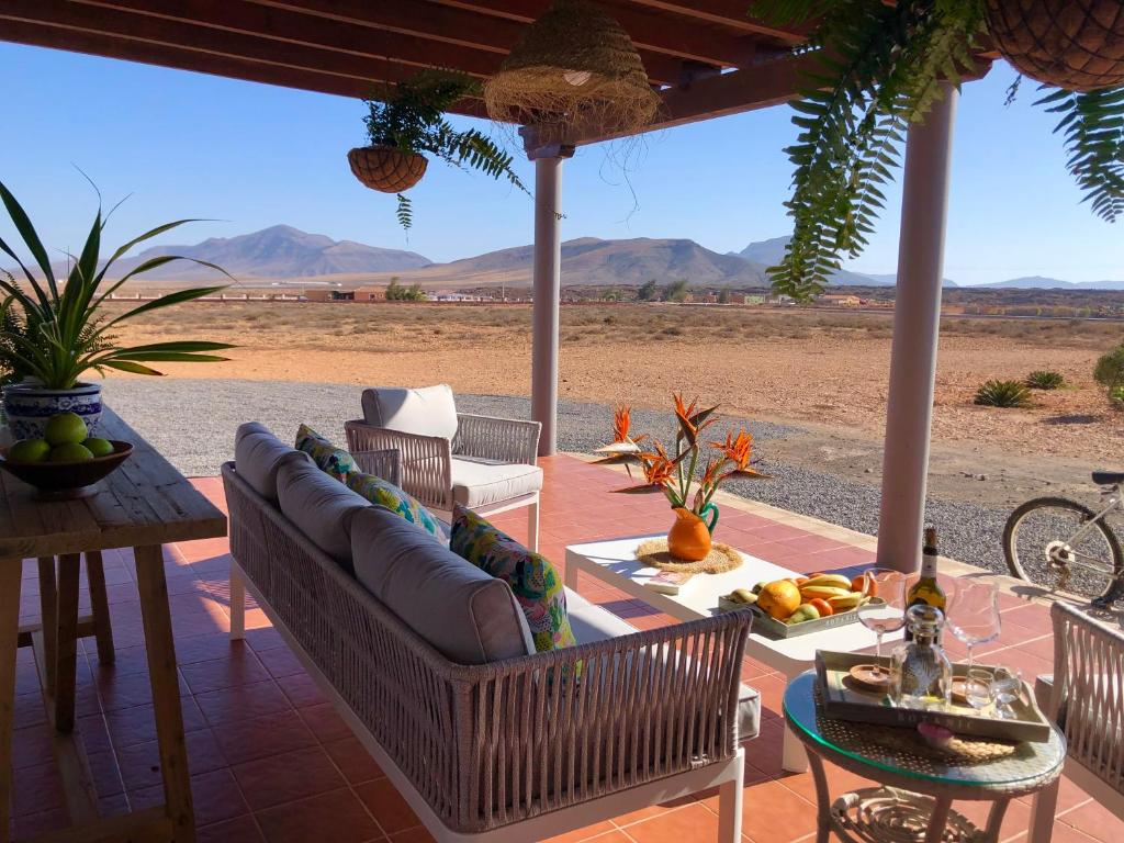 Valles de OrtegaTranquila casa rural en el centro de Fuerteventura的天井配有沙发和桌子,享有沙漠美景