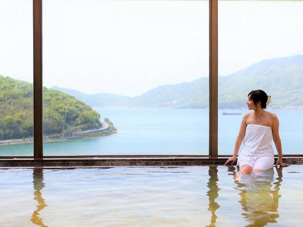 小豆岛小豆岛海湾度假酒店的坐在游泳池的水中的女人
