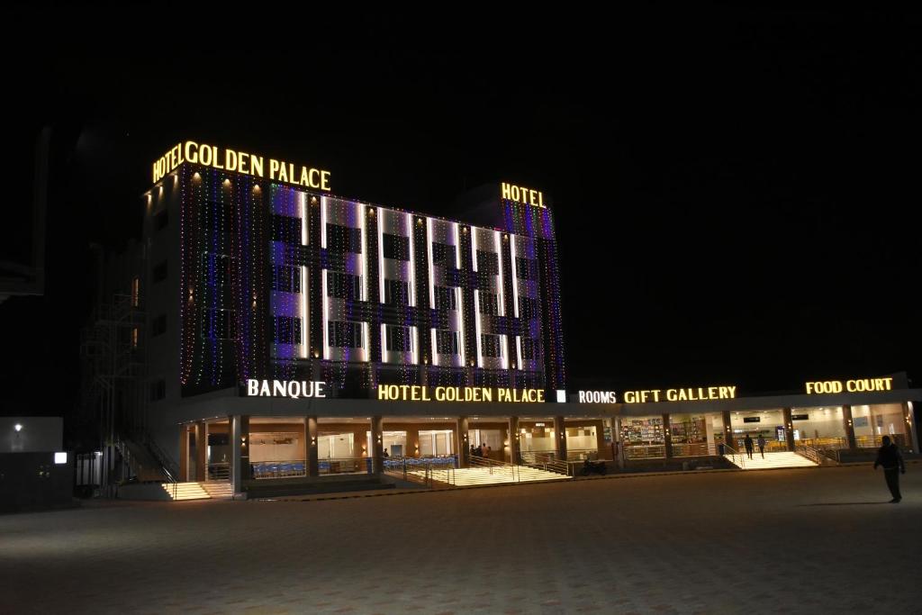 HālolHOTEL GOLDEN PALACE & ROOMS的一座在晚上有灯的大建筑