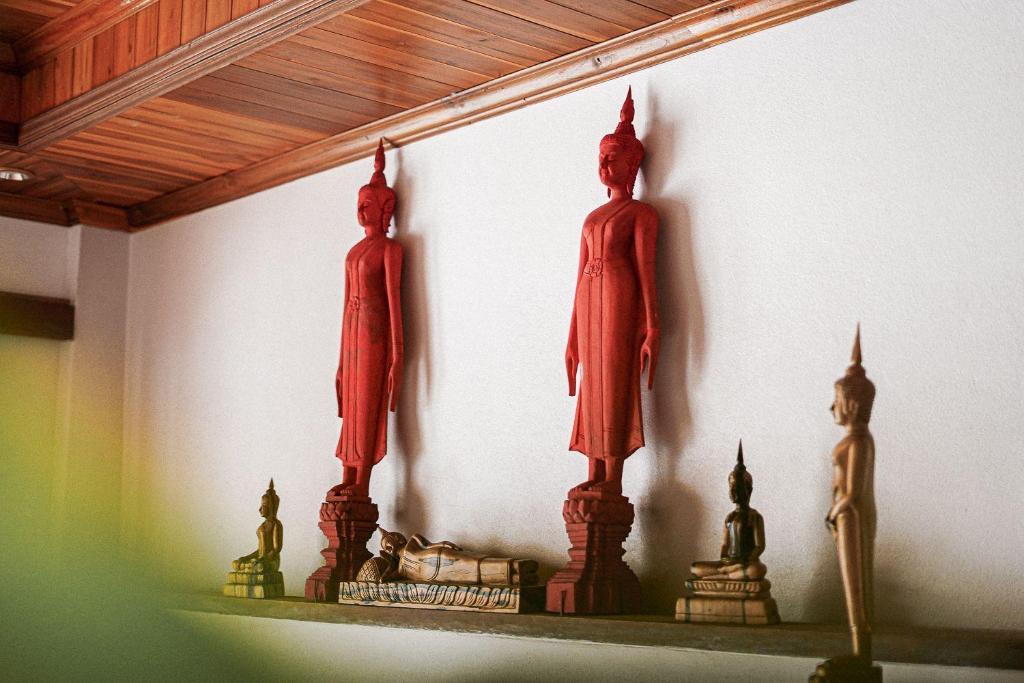 琅勃拉邦Villa Wanika的两个雕像在房间架子上