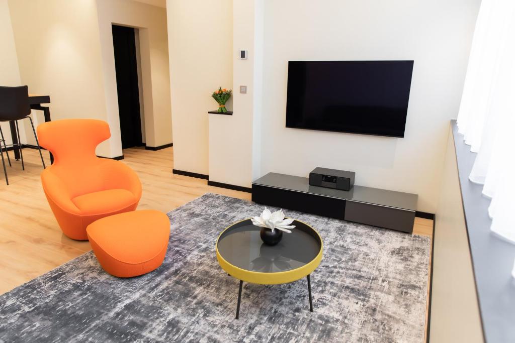 第戎Suite Montrachet 4 personnes vue cathédrale 1 Place de parking的客厅配有橙色椅子和电视