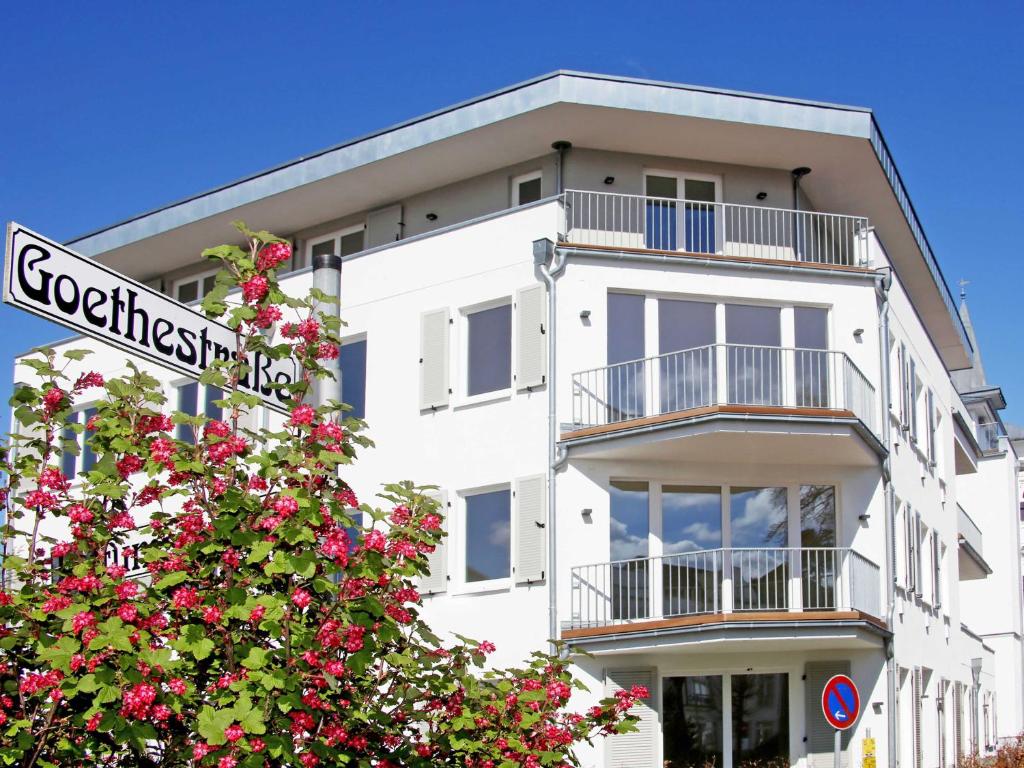 宾茨Strandhaus Seeblick - WG16 mit Meerblick的前面有一棵开花的树的白色建筑