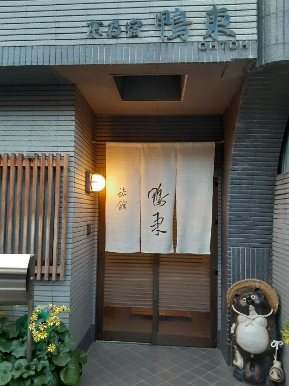 京都OHTO Ryokan的建筑物的前门,上面有标志