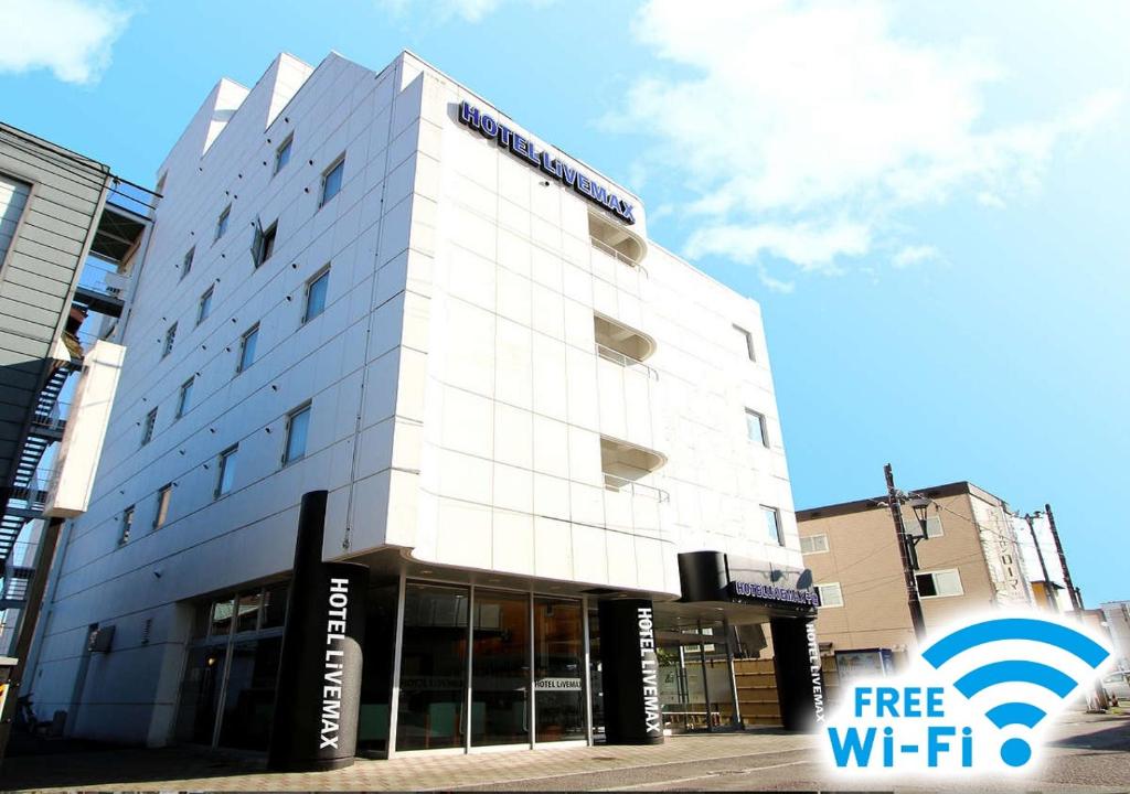 千岁HOTEL LiVEMAX BUDGET Chitose的白色的建筑,上面有免费的无线网络信号